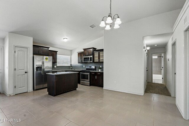 12469 Lanchester Dr, El Paso, TX 79928 - kitchen with appliances with stainless steel finishes, a chandelier, tasteful backsplash, dark brown cabinetry, and a center island