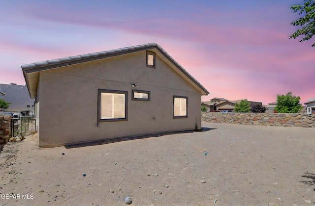 12469 Lanchester Dr, El Paso, TX 79928 - back of house at dusk featuring stucco siding