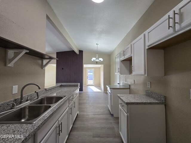1607 Gene Torres Dr, El Paso, TX 79936 - kitchen featuring wood finished floors, a chandelier, decorative light fixtures, and white cabinetry