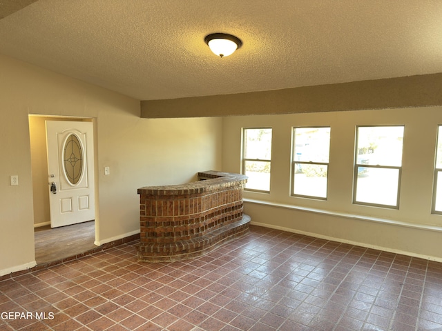 378 Hourglass Dr, El Paso, TX 79915 - spare room with a textured ceiling, vaulted ceiling, and tile patterned flooring