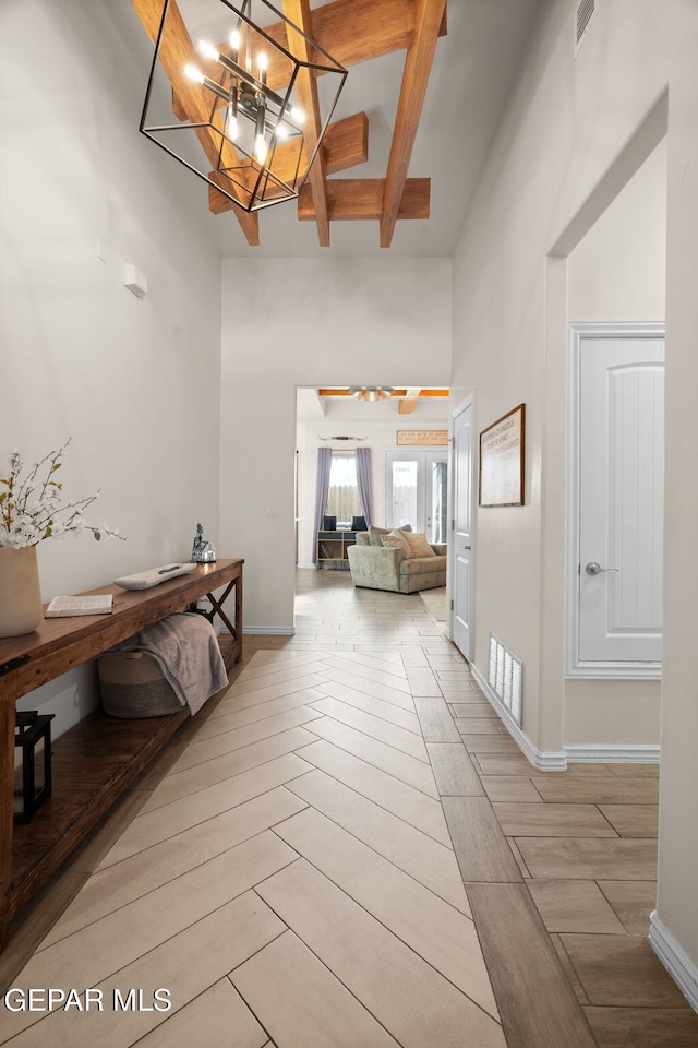 14516 Ciambriello Ave, El Paso, TX 79938 - corridor featuring a chandelier, beamed ceiling, light tile patterned floors, and a high ceiling