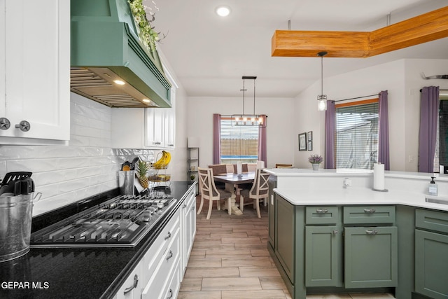 14516 Ciambriello Ave, El Paso, TX 79938 - kitchen featuring green cabinetry, custom exhaust hood, stainless steel gas cooktop, tasteful backsplash, and wood finish floors