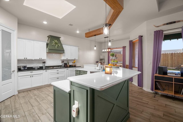 14516 Ciambriello Ave, El Paso, TX 79938 - kitchen with green cabinets, a center island with sink, white cabinetry, and recessed lighting