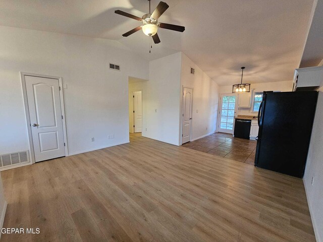 14161 Honey Point Dr, El Paso, TX 79938 - unfurnished living room with lofted ceiling, a ceiling fan, light wood finished floors, and a chandelier