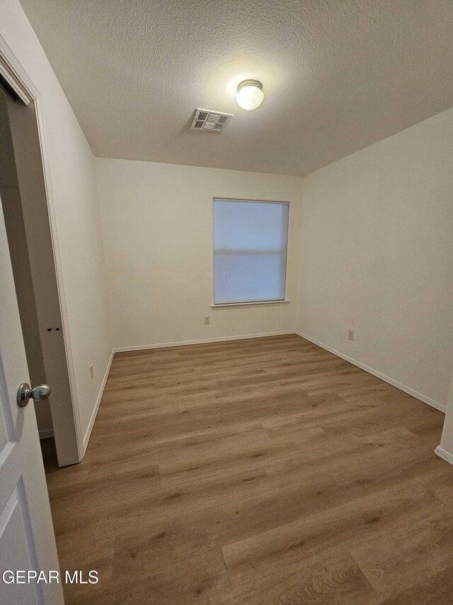 14161 Honey Point Dr, El Paso, TX 79938 - spare room featuring wood finished floors and a textured ceiling