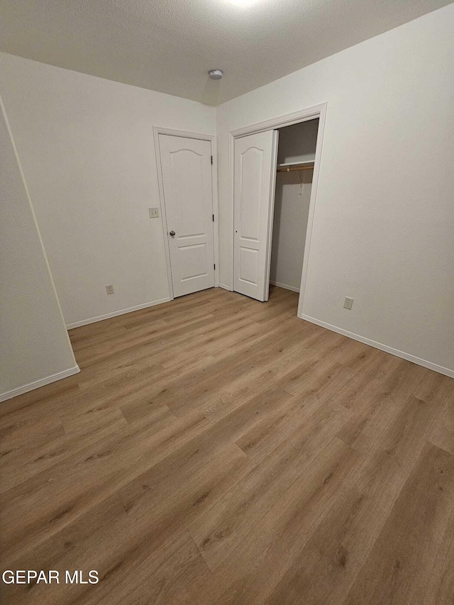 14161 Honey Point Dr, El Paso, TX 79938 - unfurnished bedroom featuring light wood finished floors and a closet