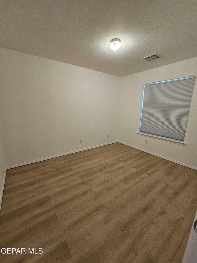 14161 Honey Point Dr, El Paso, TX 79938 - empty room featuring wood finished floors and a textured ceiling