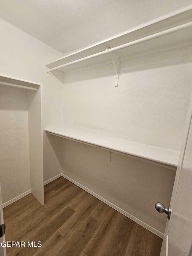 14161 Honey Point Dr, El Paso, TX 79938 - walk in closet featuring dark wood-type flooring