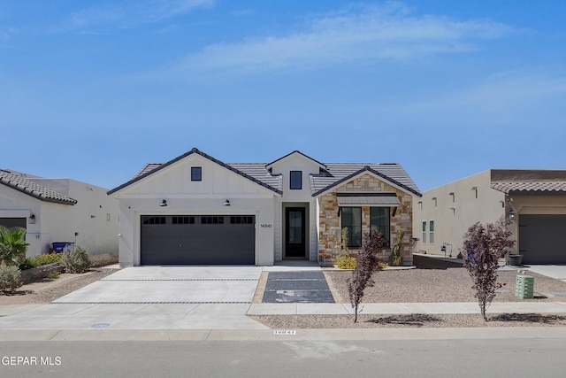 14841 Mike A Mendoza Ave, El Paso, TX 79938 - view of front facade featuring driveway, an attached garage, stone siding, and board and batten siding