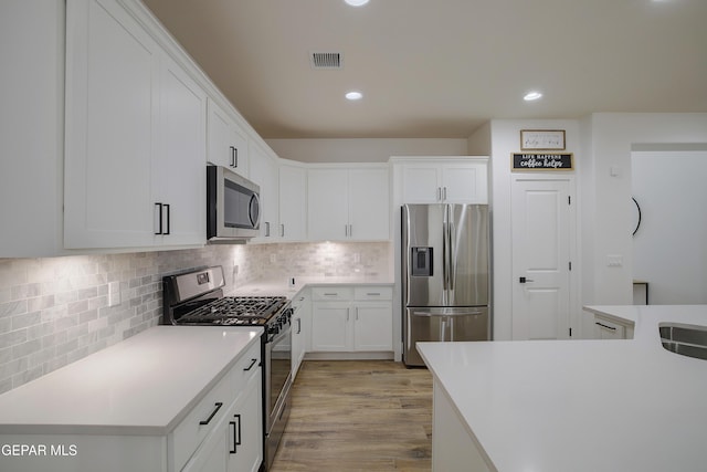 14841 Mike A Mendoza Ave, El Paso, TX 79938 - kitchen featuring appliances with stainless steel finishes, white cabinetry, light countertops, recessed lighting, and decorative backsplash