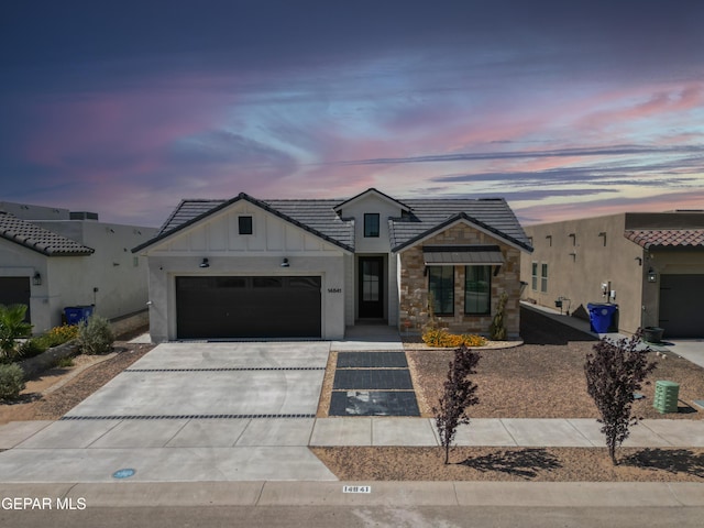 14841 Mike A Mendoza Ave, El Paso, TX 79938 - view of front of property with board and batten siding, concrete driveway, a garage, and stone siding