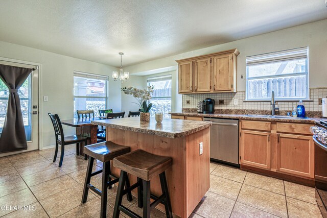 10937 Acoma St, El Paso, TX 79934 - kitchen featuring dishwasher, a center island, decorative backsplash, healthy amount of natural light, and a textured ceiling