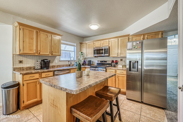 10937 Acoma St, El Paso, TX 79934 - kitchen with appliances with stainless steel finishes, light tile patterned floors, a textured ceiling, tasteful backsplash, and a center island