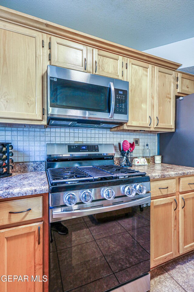 10937 Acoma St, El Paso, TX 79934 - kitchen featuring appliances with stainless steel finishes, decorative backsplash, light brown cabinets, and a textured ceiling