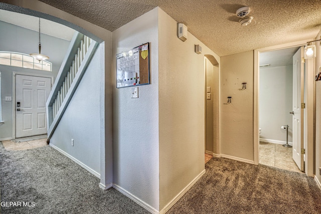 10937 Acoma St, El Paso, TX 79934 - carpeted foyer featuring arched walkways, a textured ceiling, a textured wall, and stairs