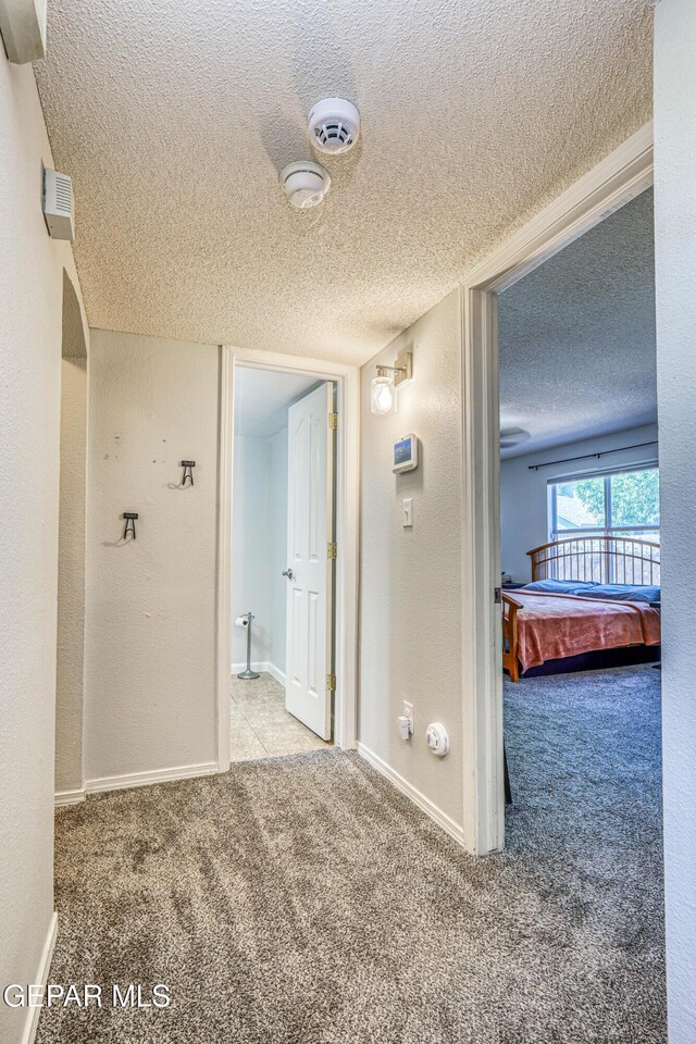 10937 Acoma St, El Paso, TX 79934 - corridor featuring a textured ceiling, carpet flooring, and a textured wall