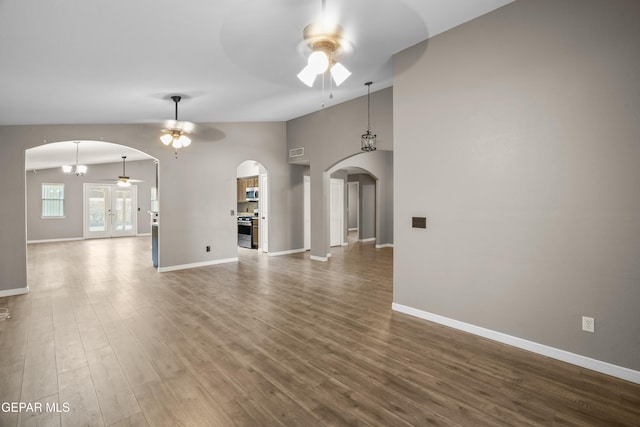 3928 Tierra Roman Dr, El Paso, TX 79938 - unfurnished living room featuring a ceiling fan, arched walkways, lofted ceiling, and wood finished floors