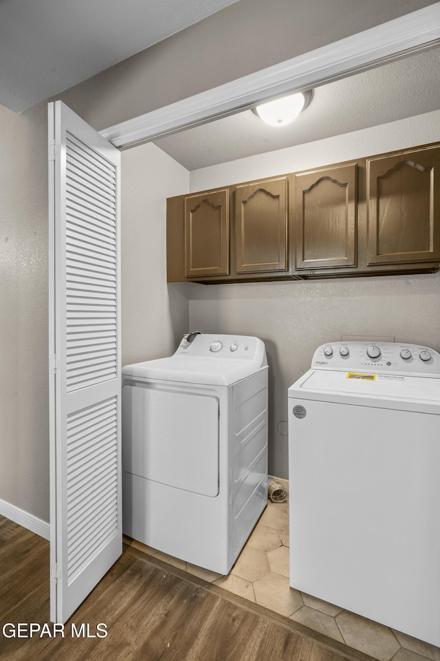 3928 Tierra Roman Dr, El Paso, TX 79938 - washroom featuring washing machine and clothes dryer, cabinet space, and wood finished floors