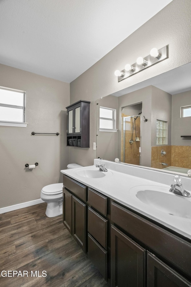 3928 Tierra Roman Dr, El Paso, TX 79938 - full bath featuring a stall shower, double vanity, wood finished floors, and plenty of natural light