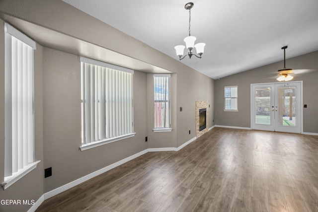 3928 Tierra Roman Dr, El Paso, TX 79938 - unfurnished living room featuring wood finished floors, lofted ceiling, a chandelier, a fireplace, and ceiling fan