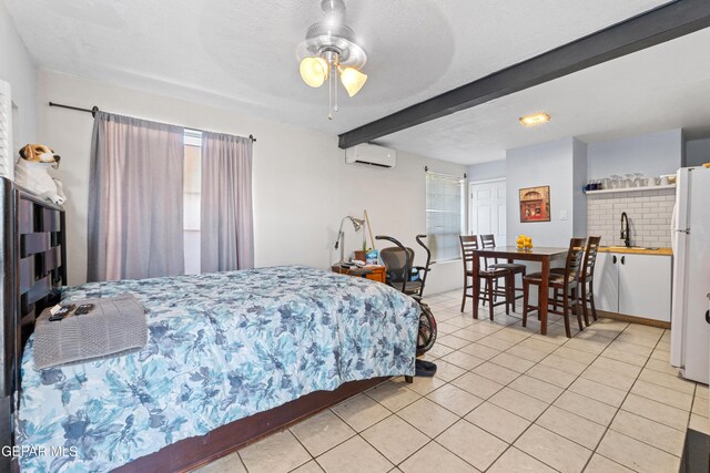 5656 Dailey Ave, El Paso, TX 79905 - bedroom featuring a wall mounted AC, freestanding refrigerator, light tile patterned floors, and beamed ceiling