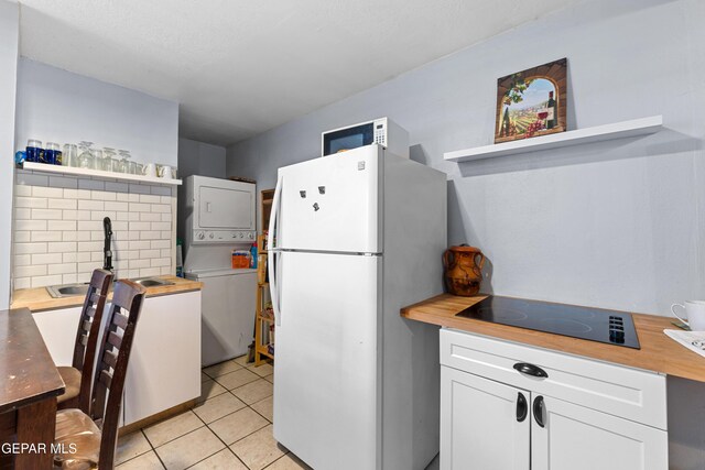 5656 Dailey Ave, El Paso, TX 79905 - kitchen featuring white appliances, wood counters, stacked washer and clothes dryer, open shelves, and white cabinets