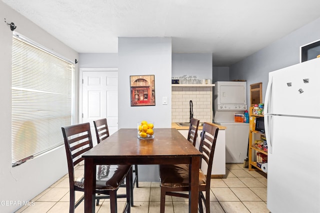 5656 Dailey Ave, El Paso, TX 79905 - dining room featuring stacked washer / drying machine and light tile patterned floors
