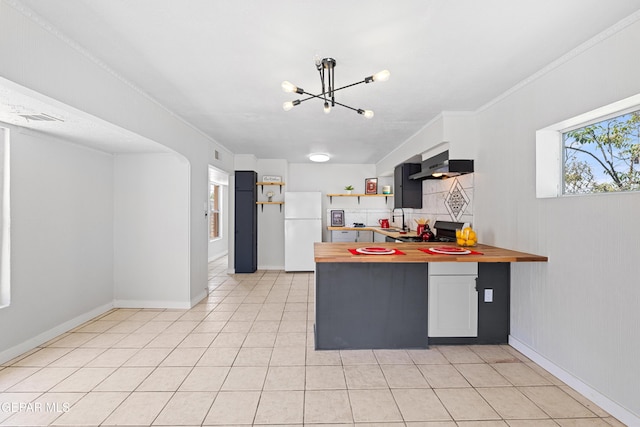 5656 Dailey Ave, El Paso, TX 79905 - kitchen featuring freestanding refrigerator, exhaust hood, butcher block counters, and a chandelier