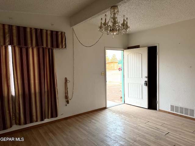 9212 Atun Way, El Paso, TX 79907 - unfurnished room with a chandelier, wood finished floors, and a textured ceiling