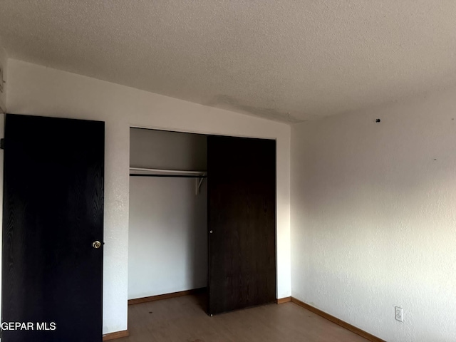 9212 Atun Way, El Paso, TX 79907 - unfurnished bedroom with a closet, a textured ceiling, and wood finished floors