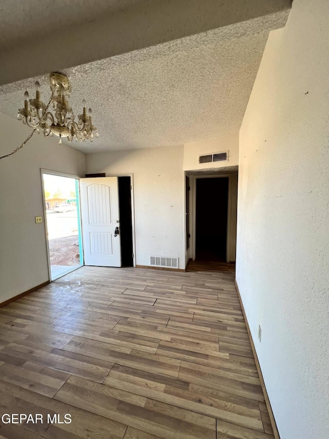 9212 Atun Way, El Paso, TX 79907 - unfurnished room featuring a chandelier, a textured ceiling, and wood finished floors