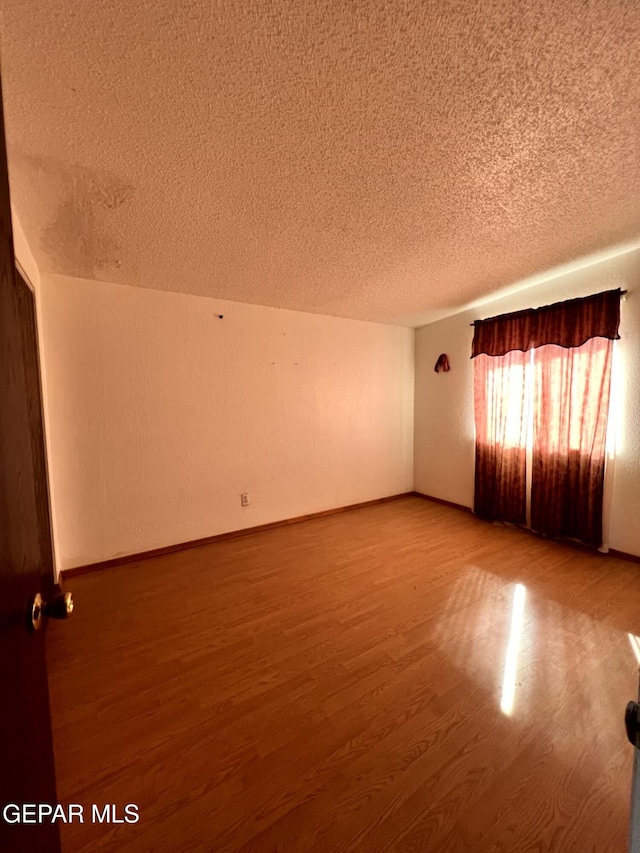 9212 Atun Way, El Paso, TX 79907 - empty room featuring a textured ceiling and wood finished floors