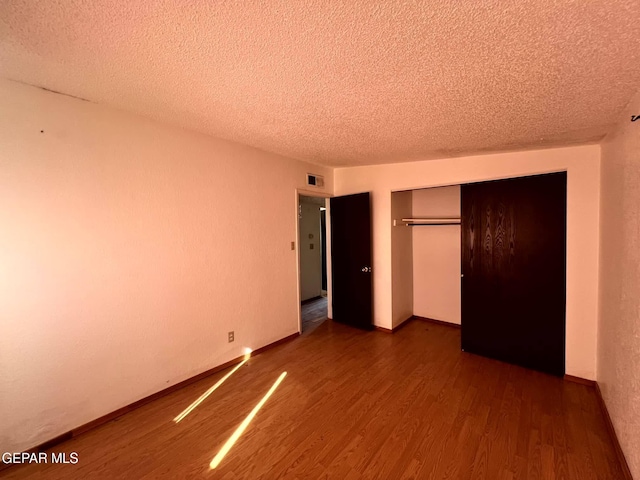 9212 Atun Way, El Paso, TX 79907 - unfurnished bedroom featuring dark wood-type flooring, a textured ceiling, and a closet
