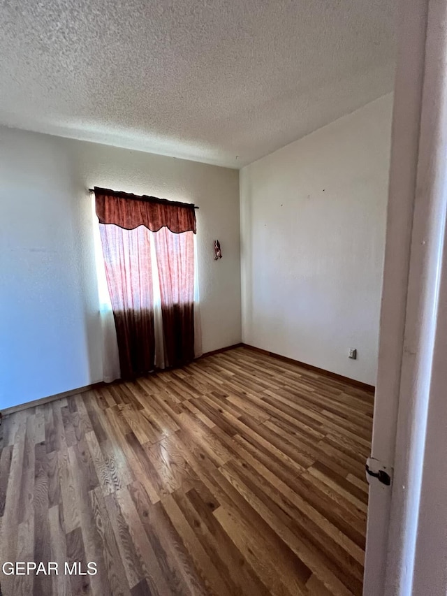 9212 Atun Way, El Paso, TX 79907 - empty room featuring a textured ceiling and wood finished floors