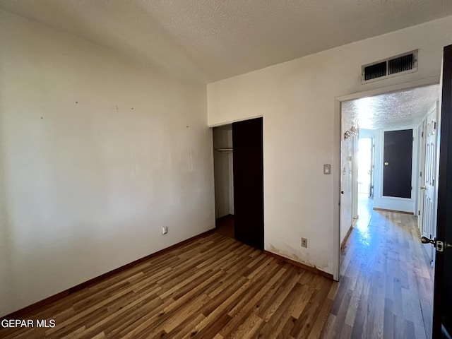 9212 Atun Way, El Paso, TX 79907 - unfurnished bedroom featuring wood finished floors, a closet, and a textured ceiling