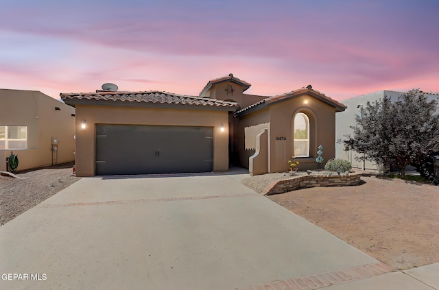 13474 Lawkland St, El Paso, TX 79928 - mediterranean / spanish-style home featuring concrete driveway, a garage, stucco siding, and a tile roof