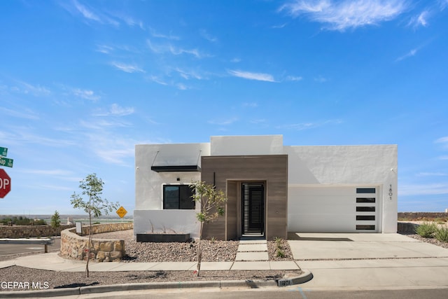 1802 Bridle, El Paso, TX 79911 - contemporary house with stucco siding, concrete driveway, and an attached garage