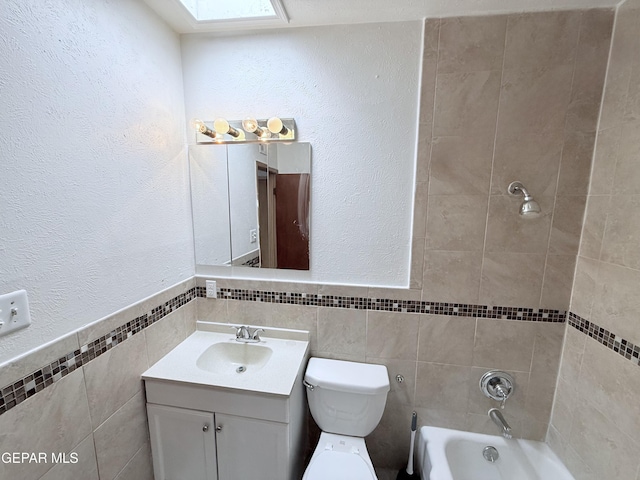 5542 Vancouver St, El Paso, TX 79924 - bathroom with tile walls, vanity, a textured wall, a skylight, and bathing tub / shower combination