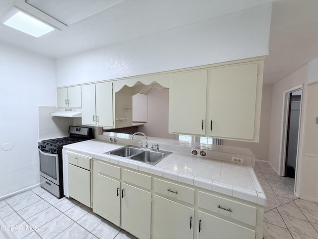 5542 Vancouver St, El Paso, TX 79924 - kitchen featuring stainless steel gas range oven, tile counters, and under cabinet range hood