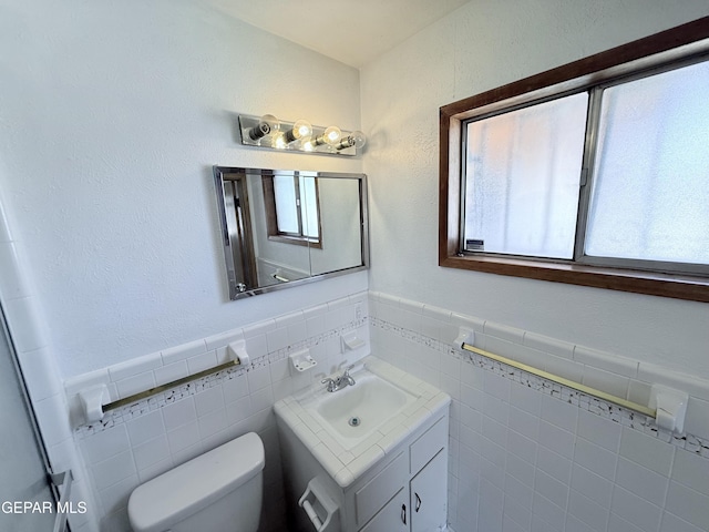 5542 Vancouver St, El Paso, TX 79924 - bathroom featuring vanity, tile walls, and wainscoting