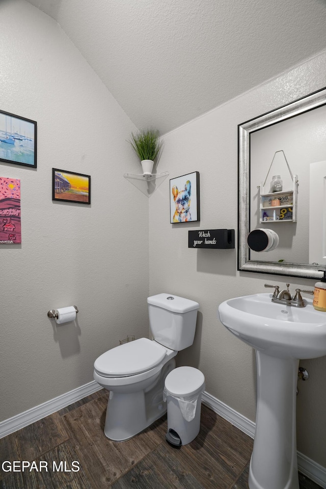10625 Hidden Links Pl, El Paso, TX 79924 - half bathroom with wood finished floors, vaulted ceiling, and a textured ceiling