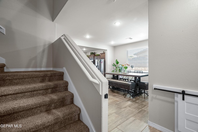 10625 Hidden Links Pl, El Paso, TX 79924 - stairs featuring a barn door, wood finished floors, and recessed lighting