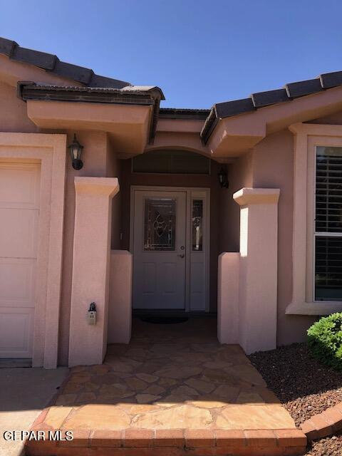 6392 Franklin Gate Dr, El Paso, TX 79912 - view of exterior entry featuring a garage and stucco siding