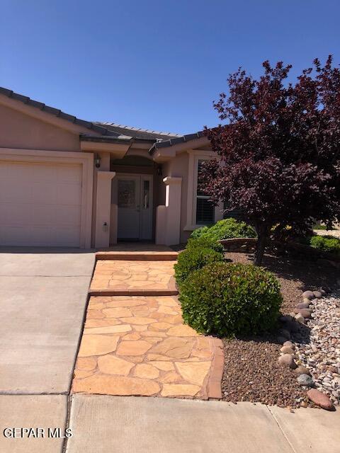 6392 Franklin Gate Dr, El Paso, TX 79912 - view of front of home with a tile roof, an attached garage, stucco siding, and concrete driveway
