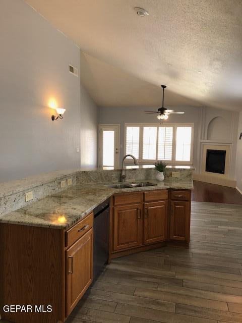 6392 Franklin Gate Dr, El Paso, TX 79912 - kitchen with dishwasher, dark wood-style flooring, ceiling fan, lofted ceiling, and light stone countertops
