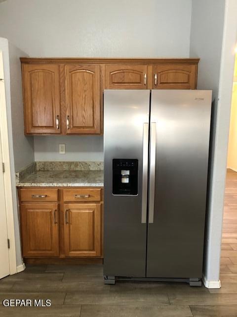 6392 Franklin Gate Dr, El Paso, TX 79912 - kitchen with stainless steel refrigerator with ice dispenser, wood finished floors, and brown cabinetry