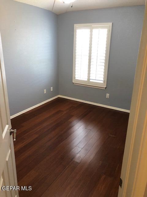 6392 Franklin Gate Dr, El Paso, TX 79912 - empty room featuring dark wood-style flooring and baseboards