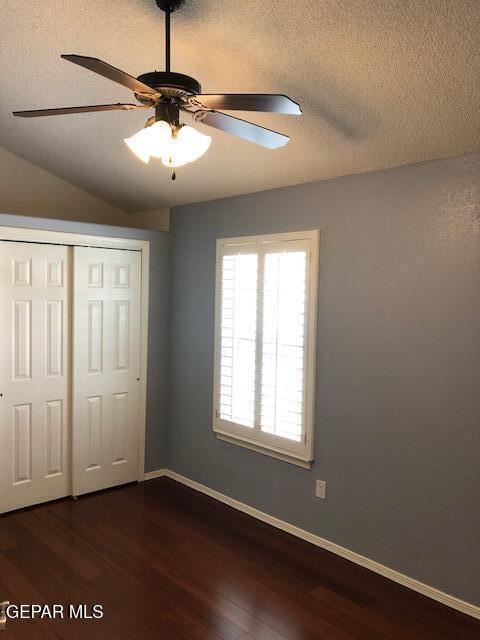 6392 Franklin Gate Dr, El Paso, TX 79912 - unfurnished bedroom with dark wood-style floors, a closet, ceiling fan, and a textured ceiling