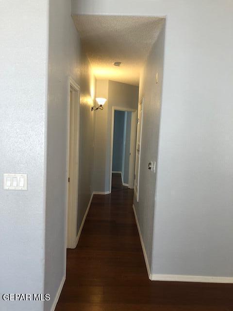 6392 Franklin Gate Dr, El Paso, TX 79912 - corridor with dark wood-type flooring and baseboards