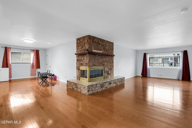 3310 Moonlight Ave, El Paso, TX 79904 - living room with healthy amount of natural light, wood finished floors, and a stone fireplace